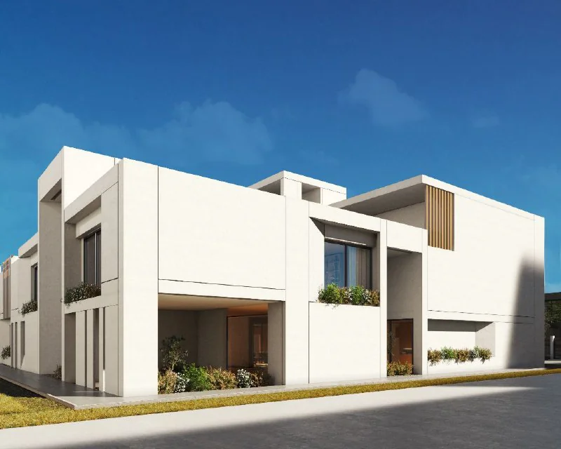 Minimalist white modern villa with clean geometric volumes and recessed entrance on a sunny street.